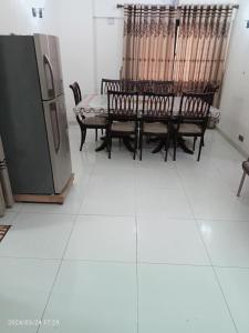 a room with chairs and a table and a refrigerator at Luxury Apartment in Karachi