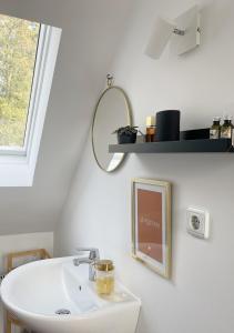 ein Badezimmer mit einem Waschbecken, einem Spiegel und einem Regal in der Unterkunft Charmante Wohnung im Hinterhof in Neukirchen-Vluyn