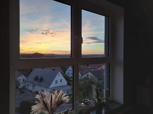 an open window with a view of a sunset at Moderne neue Dachgeschosswohnung Juliane in Goldkronach