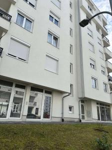 ein großes weißes Gebäude mit Fenstern und einem Straßenlicht in der Unterkunft Apartman Lena in Banja Luka
