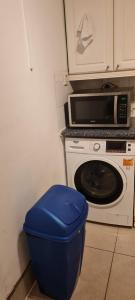 eine Küche mit einer Mikrowelle und einem blauen Mülleimer in der Unterkunft Scotland Street, Newton Heath in Manchester