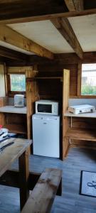 a kitchen with a stove and a refrigerator in a cabin at Camping la Vallée in La Tour-dʼAuvergne