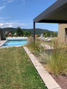 a backyard with a swimming pool and grass at Gîte "Villa Belle Vie" in Labaroche