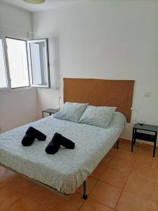 een slaapkamer met een bed met twee zwarte slippers erop bij Capital House 2 in Arrecife