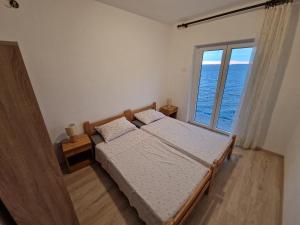 a bedroom with two beds and a large window at Apartment Lisarica in Starigrad-Paklenica