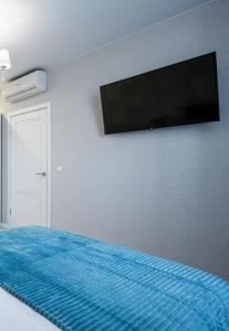 a bedroom with a bed with a flat screen tv on the wall at Warm cozy apartment with fast wi-fi in Tbilisi City