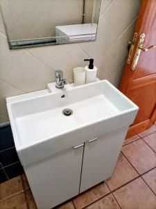 een witte wastafel in een badkamer met een spiegel bij Capital House 2 in Arrecife