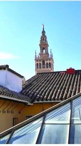 una torre del reloj en la parte superior de un edificio con techo en Conteros Centro Apartment, en Sevilla