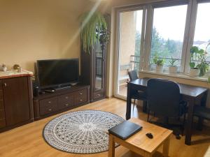 a living room with a table and a television at Apartament nad rzeką na Mazurach in Olecko