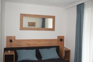 a bedroom with a bed with a mirror on the wall at Alpha Alpin Apartment in Zell am See