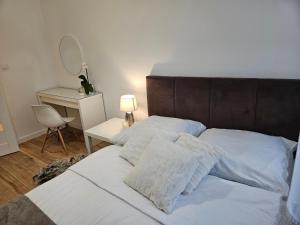 - un lit avec des draps et des oreillers blancs dans une chambre dans l'établissement Riverside Premium Apartments in City Centre, à Olsztyn