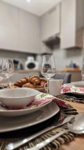 une table avec une assiette de nourriture et deux verres à vin dans l'établissement Underground Cave Apartment, à Wieliczka