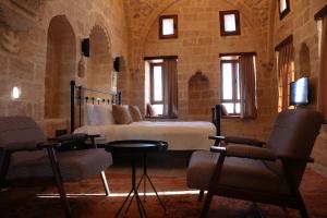 a bedroom with a bed and two chairs at Zabel Hotel in Mardin