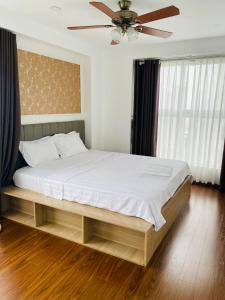 - une chambre avec un grand lit et un ventilateur de plafond dans l'établissement Three-bedroom house with sea view, à Hạ Long