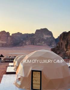 two tents in the desert with mountains in the background at Rum city Star LUXURY Camp in Wadi Rum