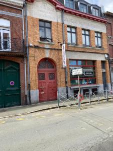 a brick building with two red doors on a street at Lille in Lille