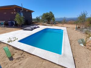 瓦爾帕萊索的住宿－Mini casa en lo alto de la montaña，庭院中间的一个蓝色游泳池