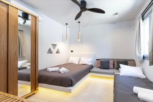 Un dormitorio con dos camas y un espejo. en Vista Mare 100 Meters to Beach with BBQ, en Kardamaina
