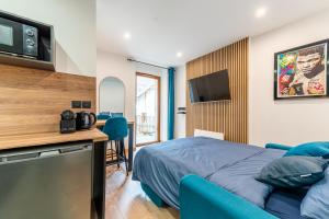 a bedroom with a bed and a tv on a wall at Studio The Greatest in Moutiers