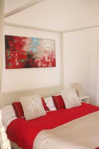una camera da letto con un letto con cuscini rossi e bianchi di Casa Tarantino Charming apartments a Capri