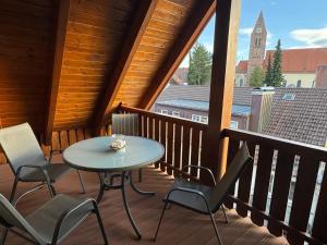 porche con mesa y sillas en el balcón en Ferienwohnungen Roiser en Bad Wörishofen