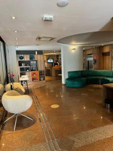 ein Wohnzimmer mit einem grünen Sofa und Stühlen in der Unterkunft M256 | Flat localizado no Jardins in São Paulo + 10 Fotos