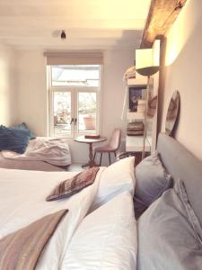 2 Betten in einem Zimmer mit einem Tisch und einem Fenster in der Unterkunft Smiling Fox Room in Löwen