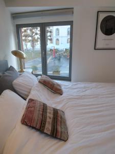 ein weißes Bett mit zwei Kissen darauf in der Unterkunft Smiling Fox Room in Löwen + 3 Fotos