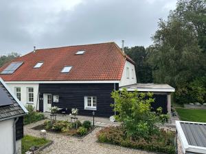 een zwart-wit huis met een rood dak bij Het Spoel in Culemborg