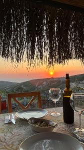 una mesa con una botella de vino y copas de vino en Pırnal Köy Evi, en Ayvacık