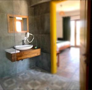 baño con lavabo y espejo en la pared en Pırnal Köy Evi, en Ayvacık