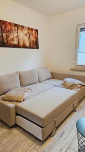 un sofá sentado en una sala de estar junto a una ventana en FeelGood Ferienwohnung, en Schweina