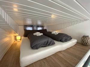 a bed with two pillows on it in a room at Tiny House am Meer in Heringsdorf