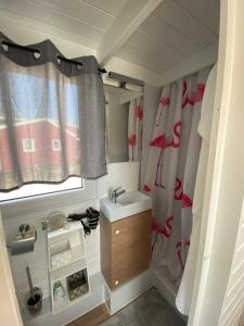 bagno con lavandino e tenda doccia di Tiny House am Meer a Heringsdorf Altre 10 foto