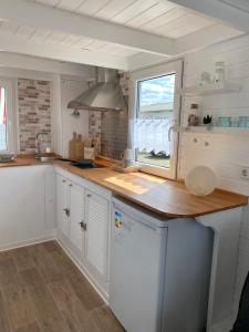 a kitchen with white cabinets and a counter with a window at Tiny House am Meer in Heringsdorf