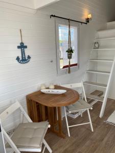 una sala da pranzo con tavolo, sedie e scala di Tiny House am Meer a Heringsdorf