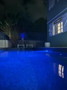 ein Pool in der Nacht mit blauer Beleuchtung in der Unterkunft CHEZ Lise et RORO in Pointe-Noire