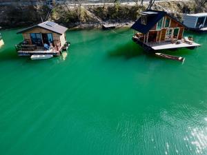 two houses on a dock in a body of water at Lake House Perucac in Rastište