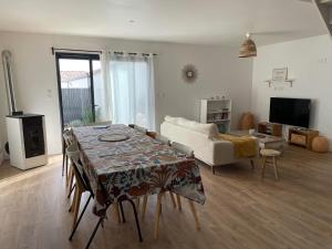uma sala de estar com uma mesa e um sofá em Maison 4 chambres - 8/10 personnes, proche mer em Brem Sur Mer