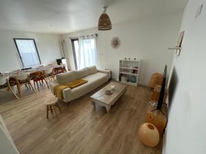 uma sala de estar com um sofá e uma mesa em Maison 4 chambres - 8/10 personnes, proche mer em Brem Sur Mer