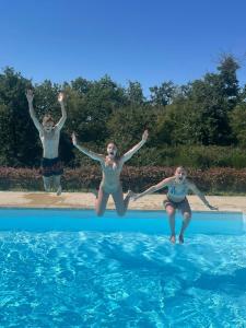 dos chicas saltando a una piscina en Château Neuf Le Désert en Le Pizou