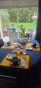 una mesa azul con comida y bebidas. en Chambres d'hôtes Les Chênes, en Acigné