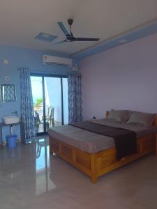 um quarto com uma cama grande e uma varanda em Saisagar beach resort em Devgarh
