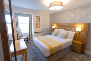 una camera d'albergo con un grande letto e una scrivania di The Resolution Hotel a Whitby