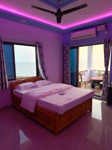 um quarto com uma cama grande e iluminação roxa em Saisagar beach resort em Devgarh