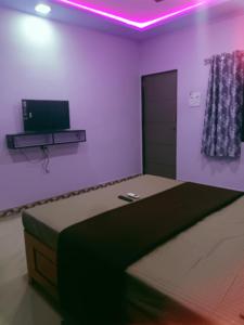 um quarto com uma cama e uma televisão na parede em Saisagar beach resort em Devgarh