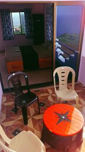 um quarto com duas cadeiras, uma cama e uma mesa em Saisagar beach resort em Devgarh