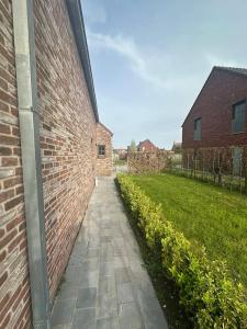 a brick wall with a walkway next to a building at THE 11 gîte pour vacances ou travail in Comines