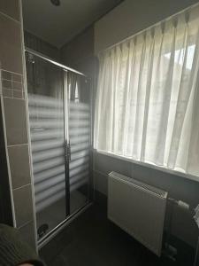 a bathroom with a shower and a window at THE 11 gîte pour vacances ou travail in Comines