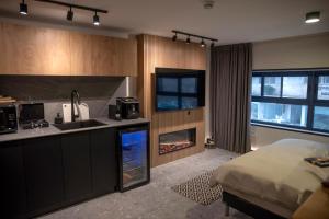 a kitchen with a bed and a kitchen with a fireplace at Urbano in Haifa